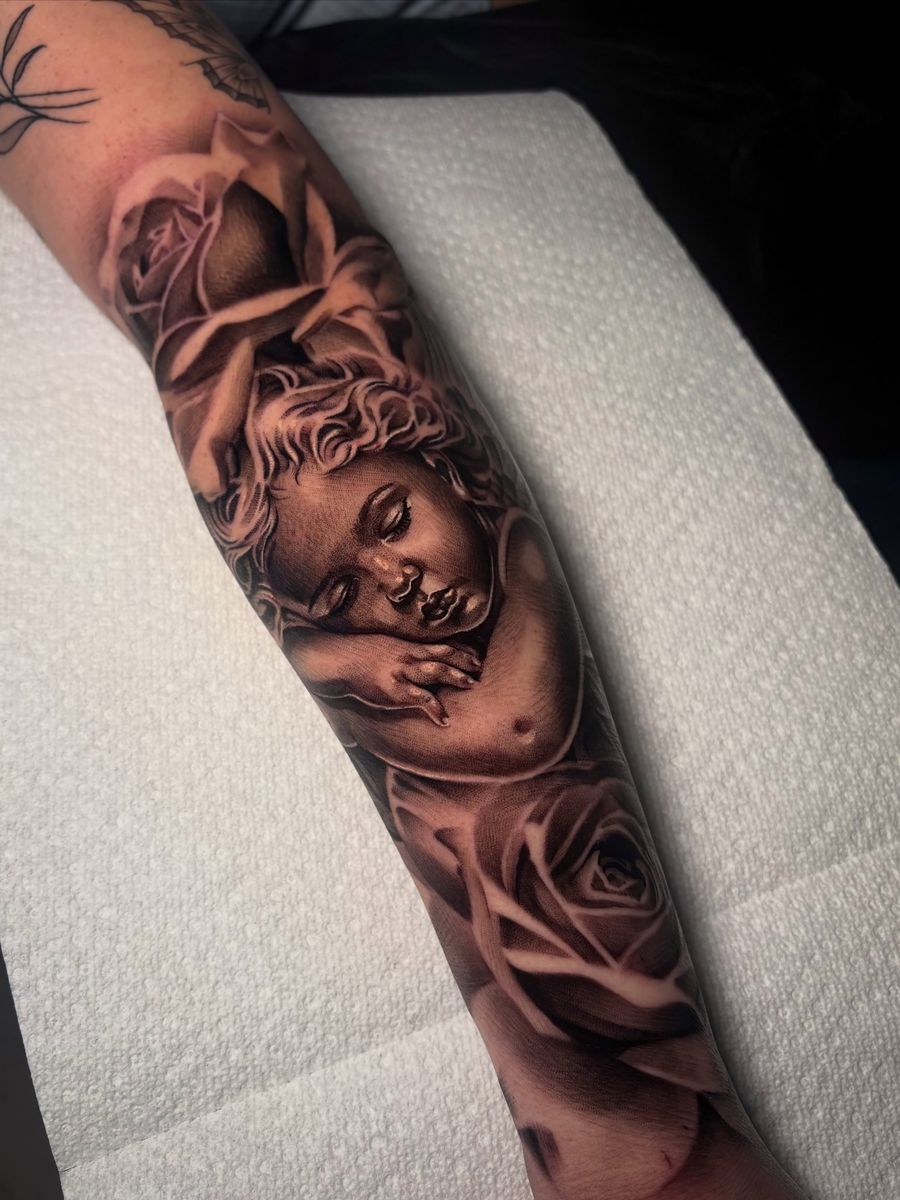 Black-and-grey cherub with roses — forearm piece by Juli
