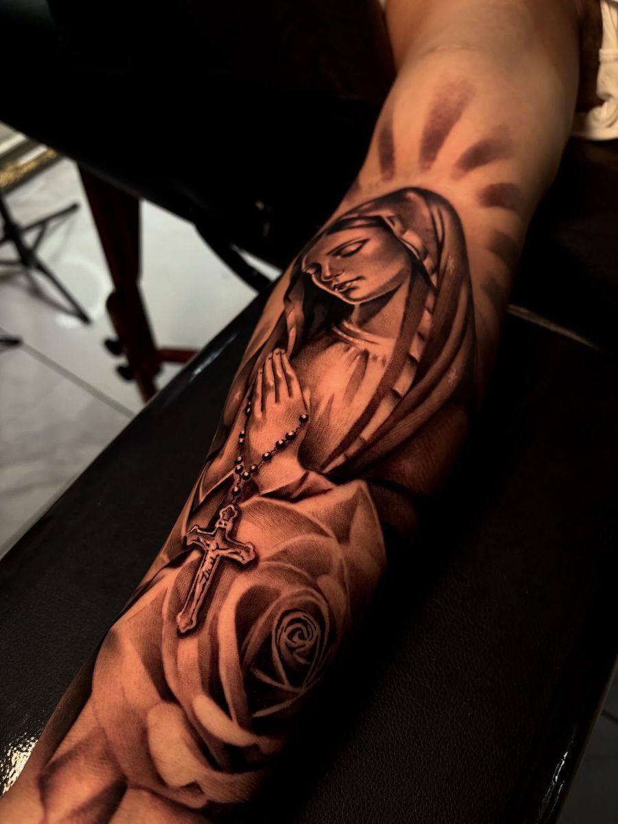 Praying Virgin Mary with rosary cross and roses — forearm tattoo